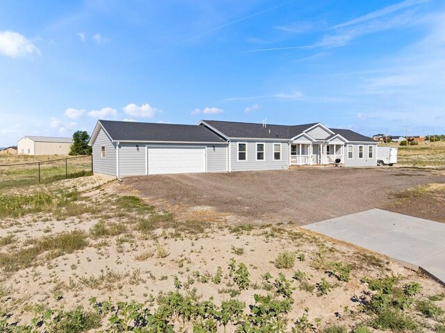 view of front of property with driveway, an attached garage, and fence