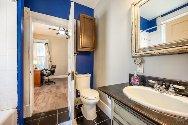 bathroom featuring vanity, toilet, baseboards, and a ceiling fan