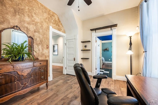 office space with lofted ceiling, baseboards, wood finished floors, and ceiling fan