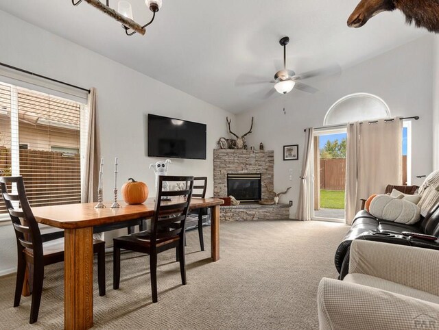 living room with a ceiling fan, lofted ceiling, light colored carpet, and a fireplace