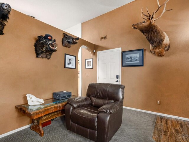 sitting room featuring baseboards, visible vents, and arched walkways