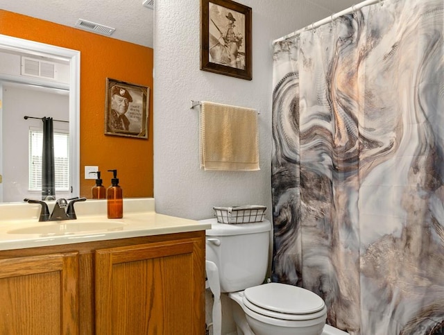 bathroom with toilet, a shower with curtain, visible vents, and vanity