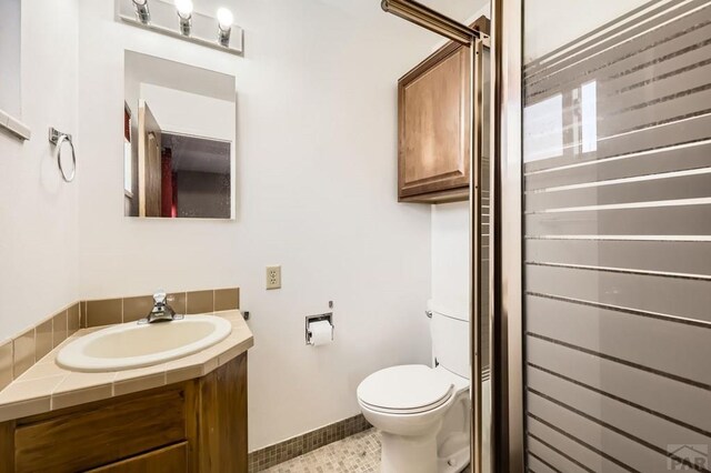 full bath with baseboards, vanity, toilet, and tile patterned floors