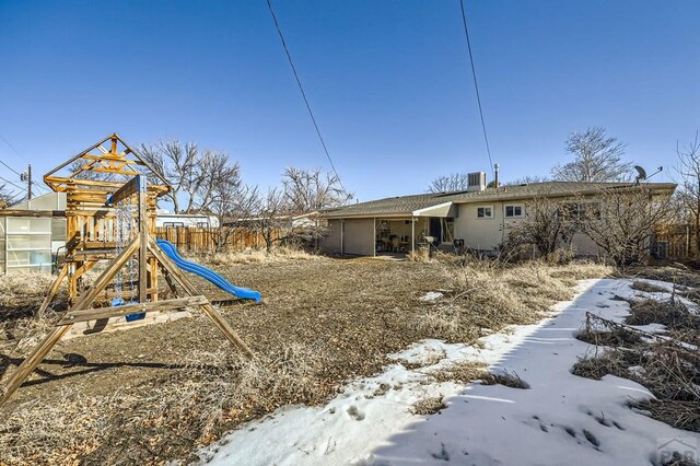 yard covered in snow with a playground