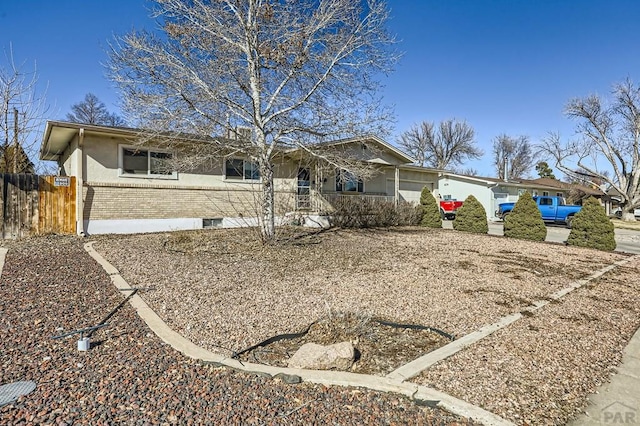 ranch-style house featuring brick siding and fence