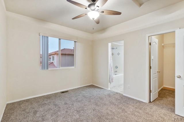 unfurnished bedroom featuring light colored carpet, visible vents, ensuite bathroom, a ceiling fan, and baseboards