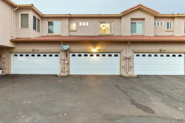 view of front of home with driveway, a garage, and stucco siding