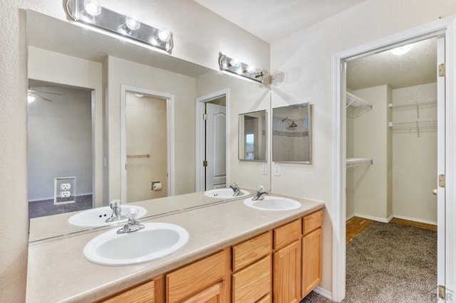 full bath featuring double vanity, baseboards, and a sink