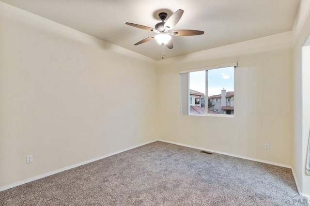 unfurnished room featuring carpet floors, ceiling fan, visible vents, and baseboards