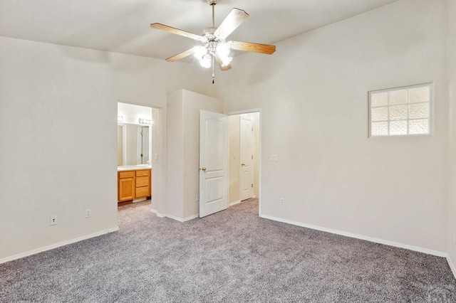 unfurnished bedroom featuring ceiling fan, baseboards, ensuite bathroom, and light colored carpet