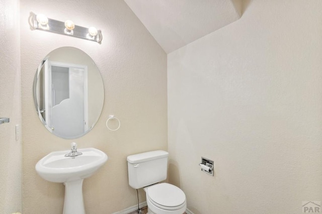 bathroom featuring baseboards and toilet