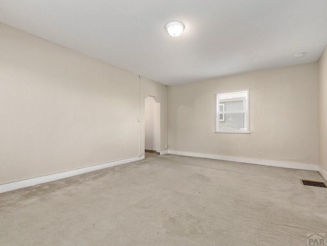 spare room featuring baseboards, visible vents, and carpet flooring