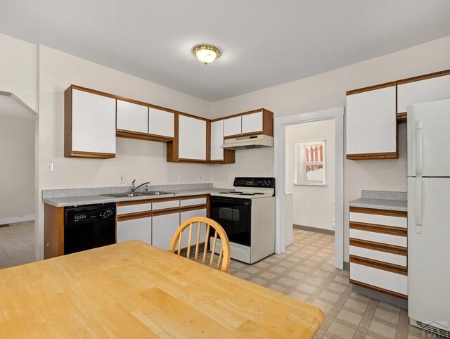 kitchen featuring white appliances, light countertops, under cabinet range hood, white cabinetry, and a sink