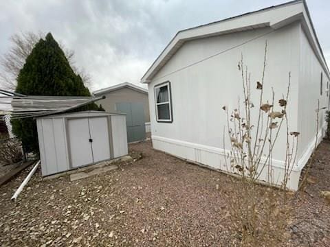 view of side of property featuring an outbuilding and a shed