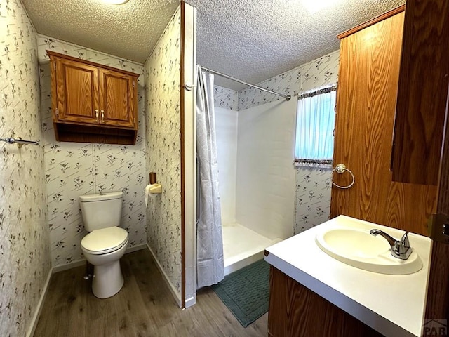 full bath featuring wallpapered walls, a textured ceiling, and wood finished floors