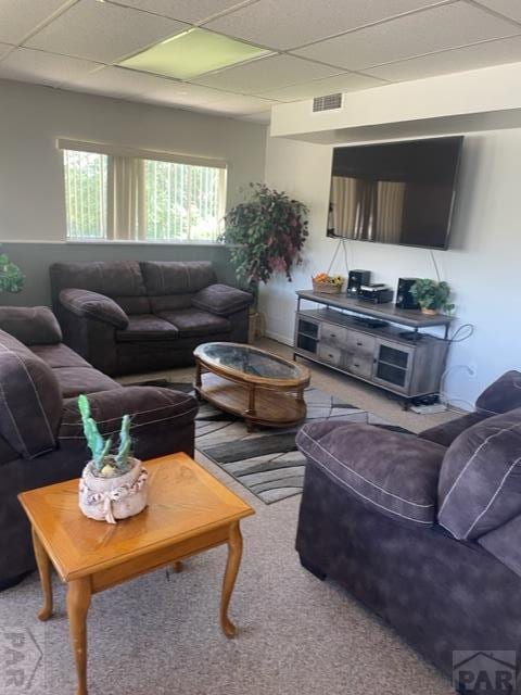 living area featuring a paneled ceiling and visible vents