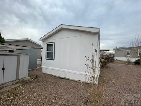 view of side of property with a storage unit and an outdoor structure