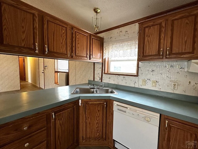 kitchen with dishwasher, a textured ceiling, a sink, and wallpapered walls