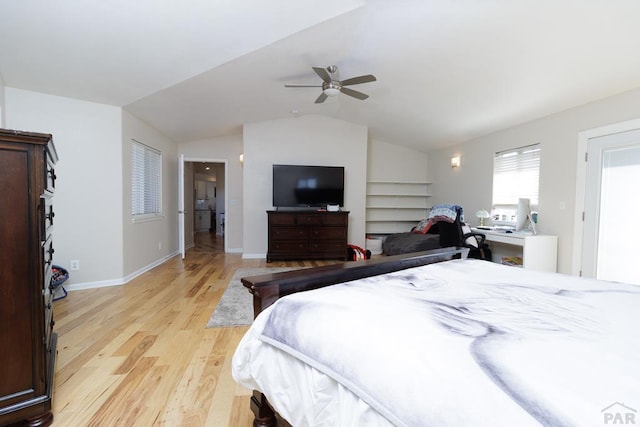 bedroom with lofted ceiling, light wood finished floors, baseboards, and a ceiling fan