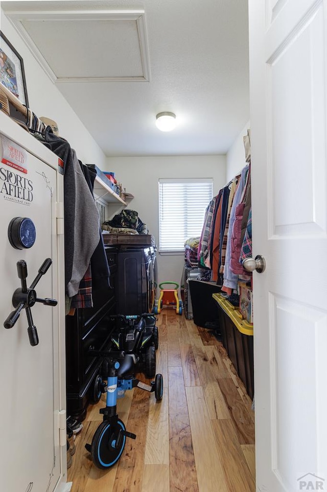 spacious closet featuring hardwood / wood-style floors and attic access