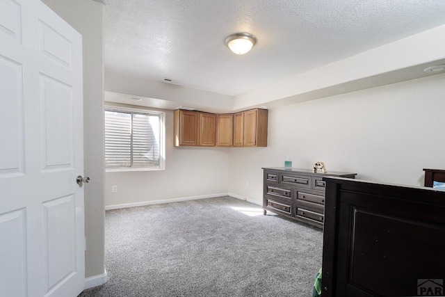 interior space featuring a textured ceiling, visible vents, and baseboards