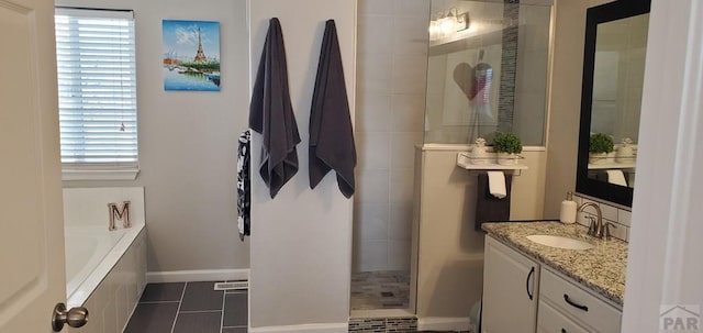 full bath featuring vanity, a bath, walk in shower, baseboards, and tile patterned floors