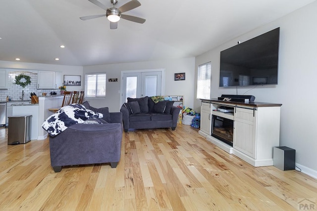 living area with light wood-style flooring, a ceiling fan, a wealth of natural light, and recessed lighting