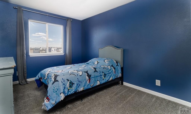 bedroom featuring dark carpet and baseboards