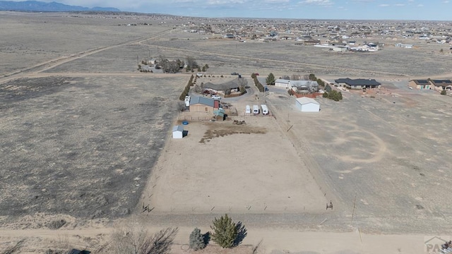 drone / aerial view featuring a desert view and a mountain view