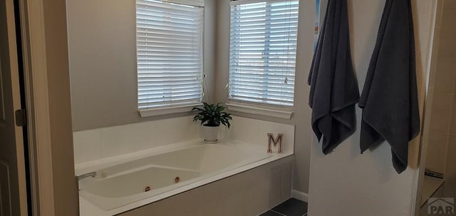 bathroom with a jetted tub and a healthy amount of sunlight