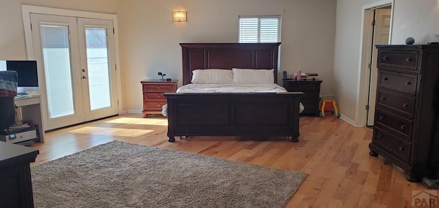 bedroom featuring access to exterior, baseboards, light wood finished floors, and french doors