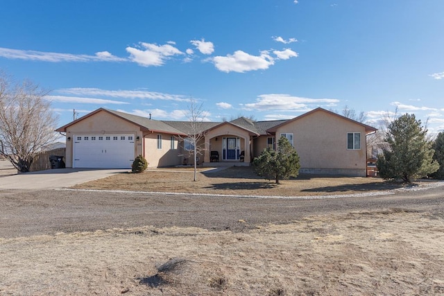 ranch-style home with an attached garage, concrete driveway, and stucco siding