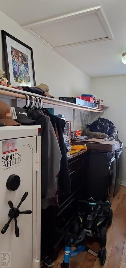 spacious closet with attic access and wood finished floors