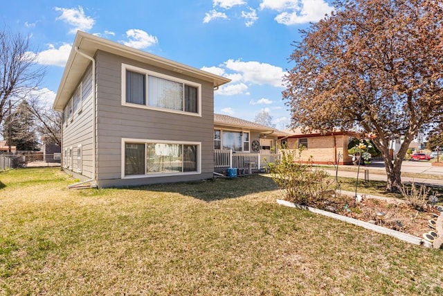 back of property with a yard and fence