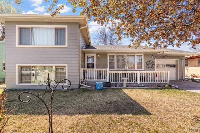 split level home with a garage, a front yard, driveway, and covered porch