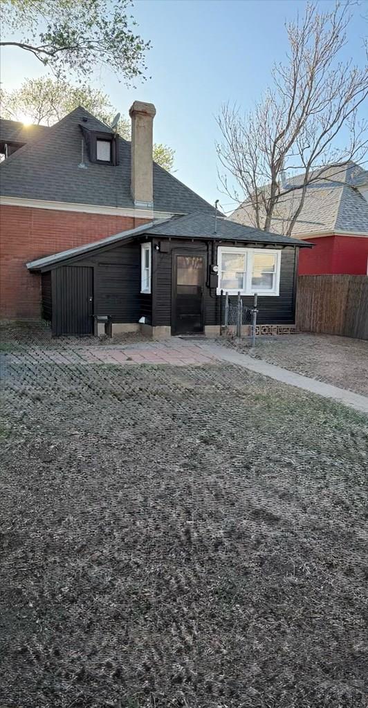rear view of property with fence and a chimney