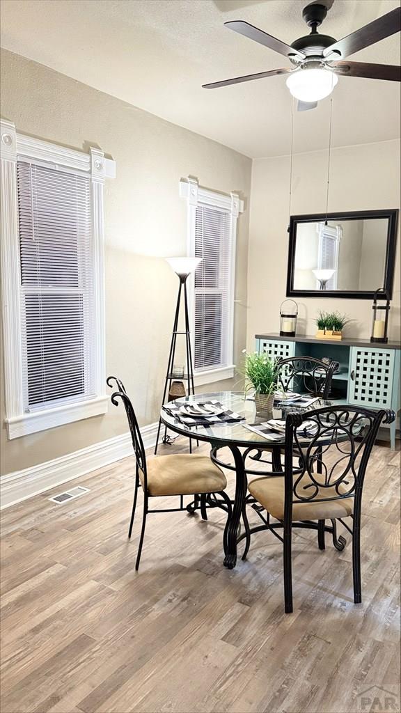 dining room with visible vents, baseboards, ceiling fan, and light wood-type flooring