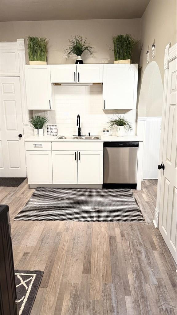 kitchen featuring white cabinetry, tasteful backsplash, a sink, and dishwasher