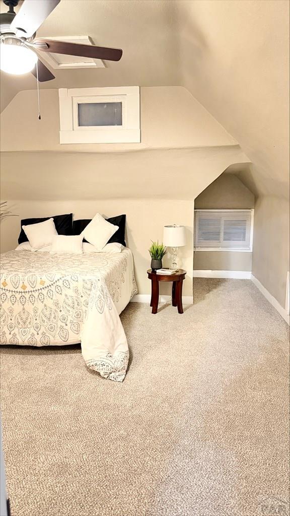 carpeted bedroom featuring baseboards, ceiling fan, and lofted ceiling