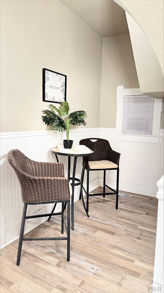 sitting room featuring wainscoting and wood finished floors