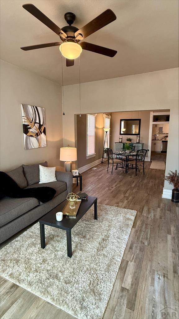 living area with ceiling fan and wood finished floors
