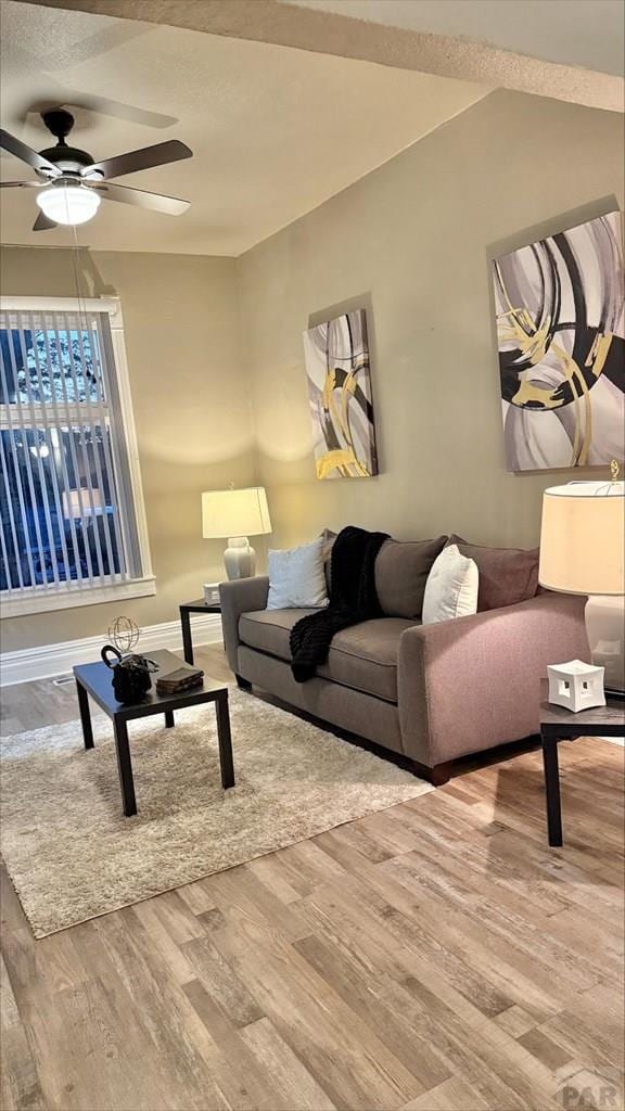 living room with a ceiling fan and wood finished floors