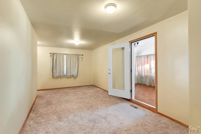 empty room featuring carpet, visible vents, and baseboards