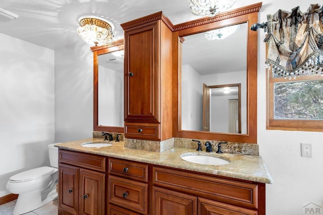 bathroom with tile patterned floors, a sink, toilet, and double vanity