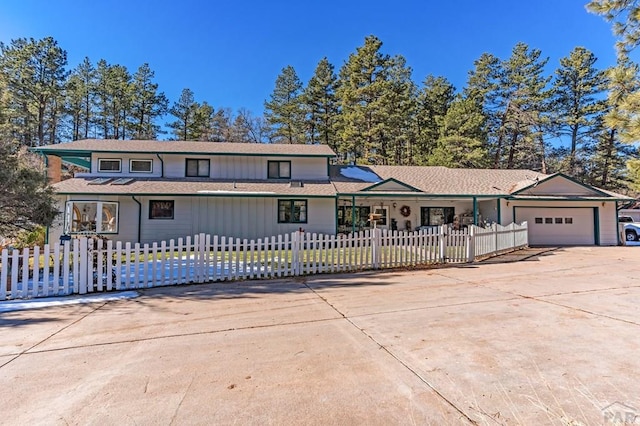 view of front facade featuring a fenced front yard, driveway, and a garage