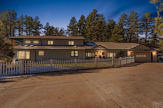 view of front of home with a garage, driveway, and a fenced front yard