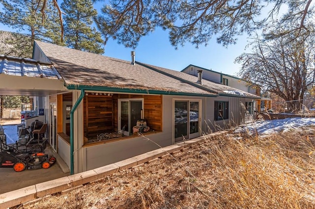 back of property with a shingled roof