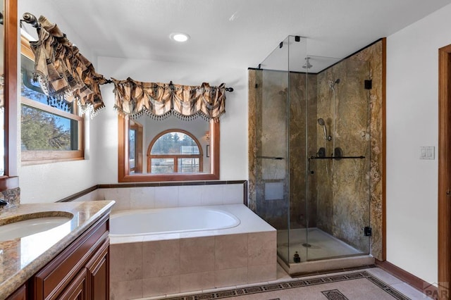 bathroom featuring a bath, a shower stall, and vanity