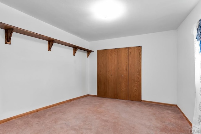 unfurnished room featuring light carpet and baseboards