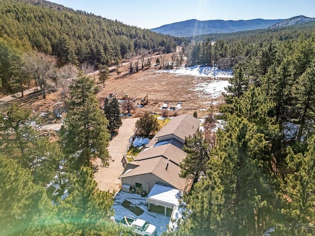 drone / aerial view with a mountain view and a view of trees